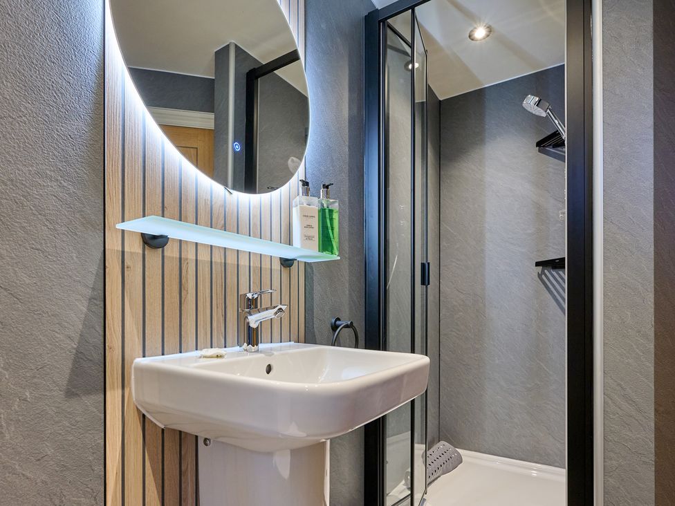 A bathroom with a sink and shower at Riverside Park 3 in Keswick