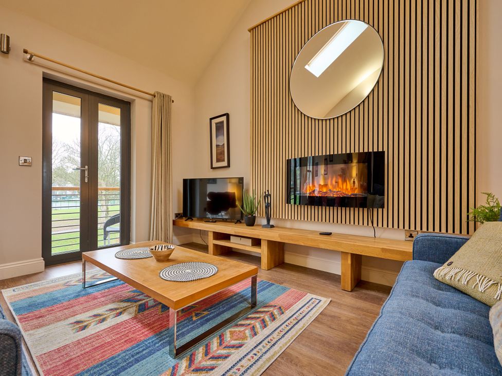 A living room with a television and sofa at Riverside Park 5 in Keswick