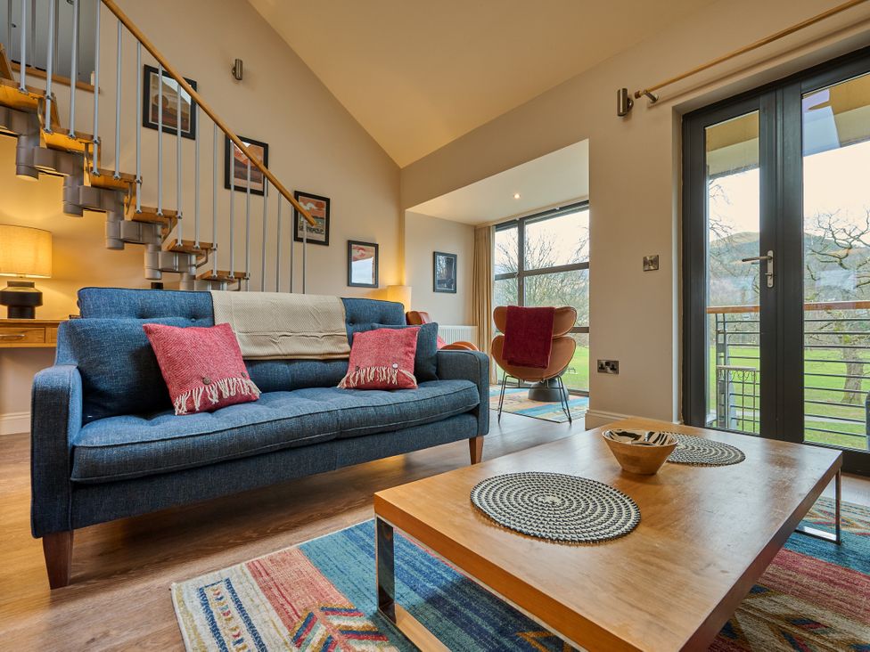 A living room featuring a sofa, coffee table, and staircase at Riverside Park 5 in Keswick