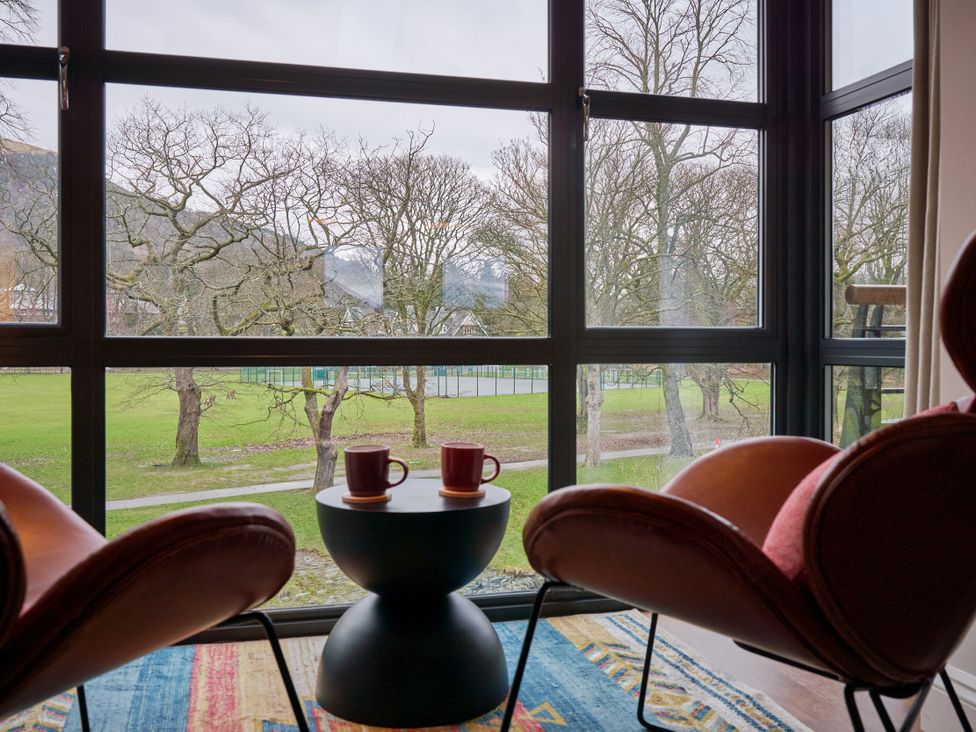 A cozy living room with chairs and a view of trees at Riverside Park 5 in Keswick