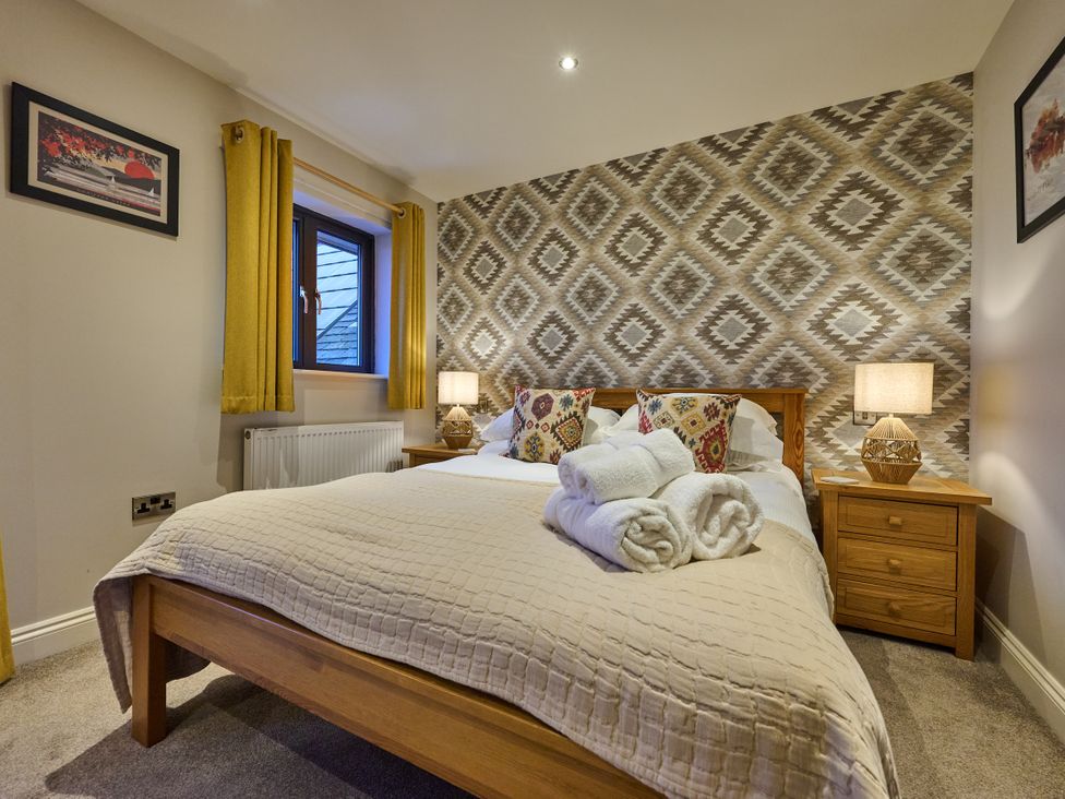 A bedroom with a bed and bedside tables at Riverside Park 5 in Keswick