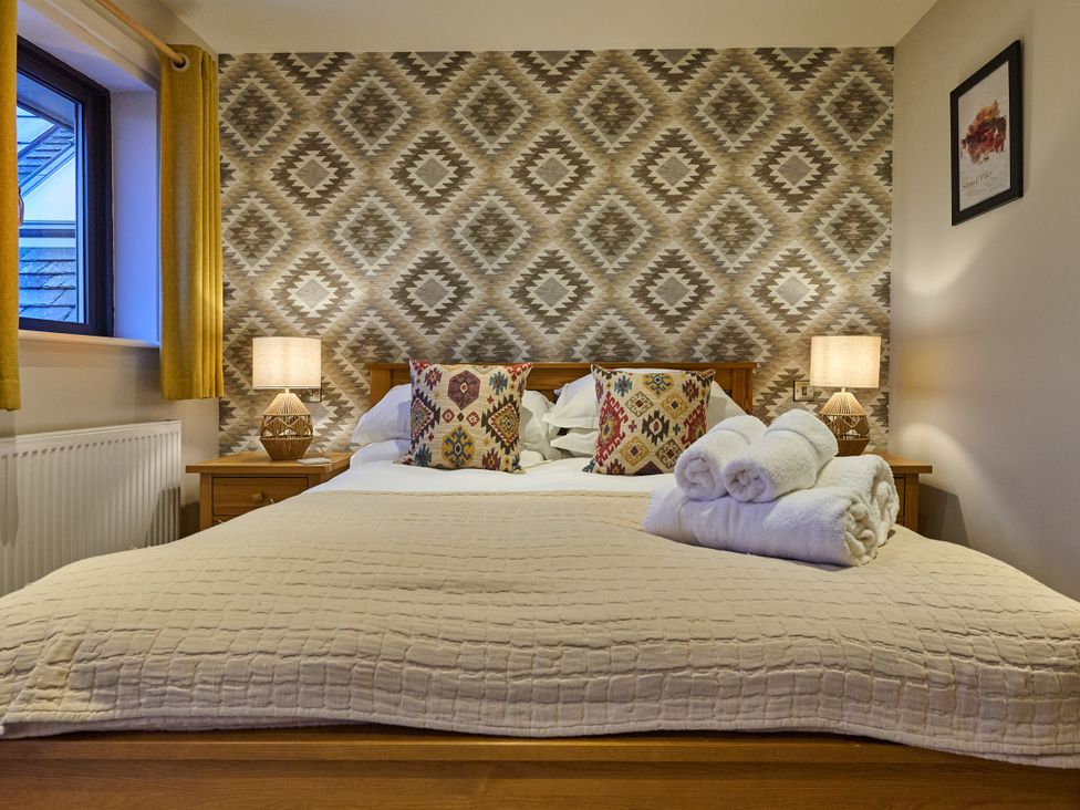 A bedroom with a bed and decorative pillows at Riverside Park 5 in Keswick