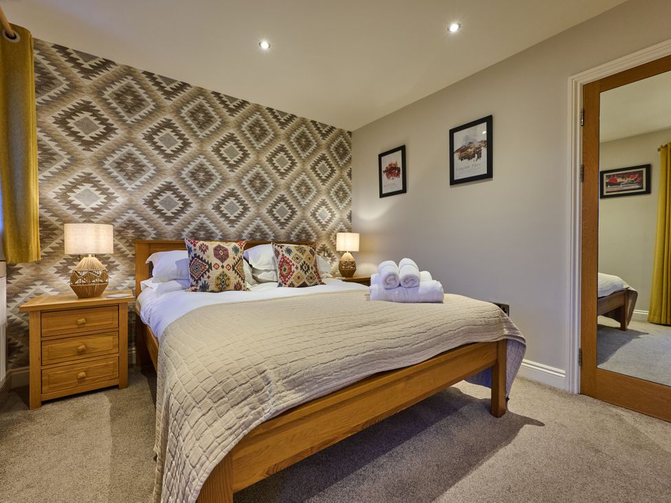 A bedroom with a bed and nightstand at Riverside Park 5 in Keswick