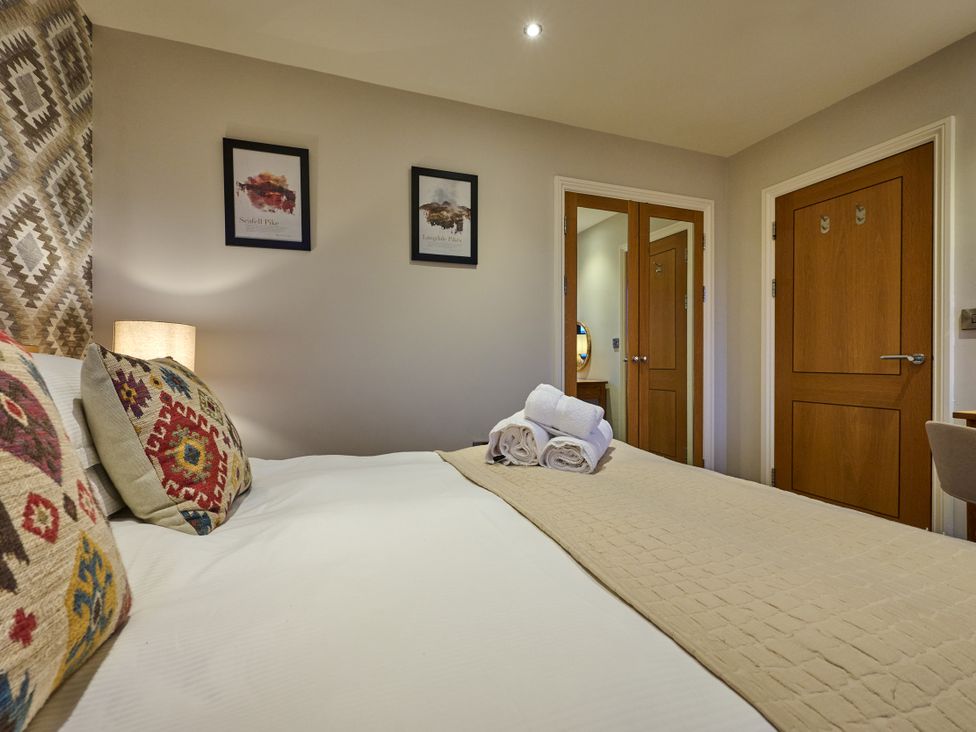 A bedroom with a bed and towels at Riverside Park 5 in Keswick