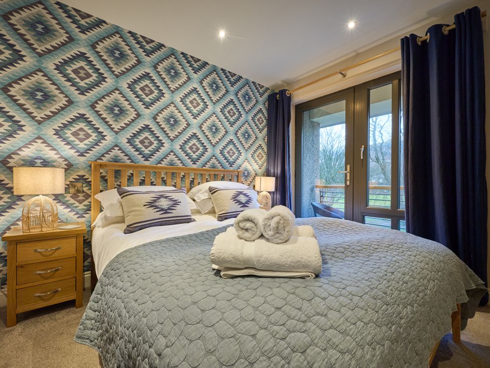 A bedroom with a double bed and a nightstand at Riverside Park 5 in Keswick