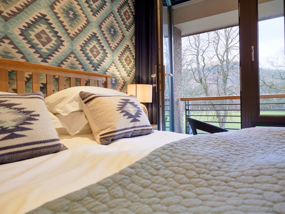 A bedroom featuring a bed with pillows and a view of the outdoors at Riverside Park 5 Keswick