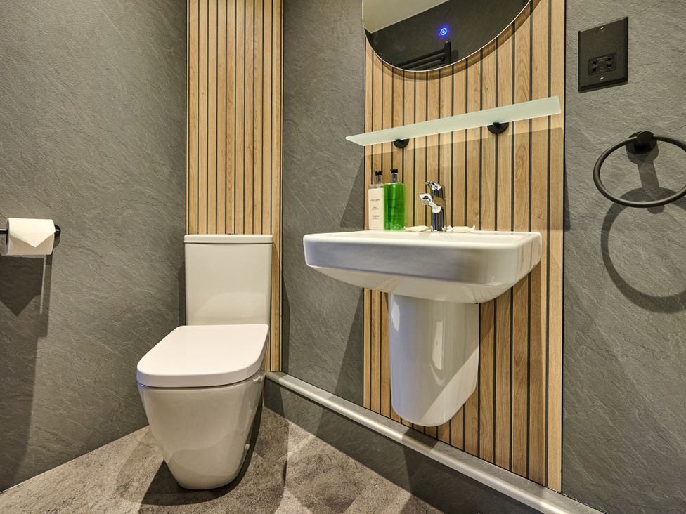 A bathroom with a sink, toilet, and a mirror at Riverside Park 5 in Keswick