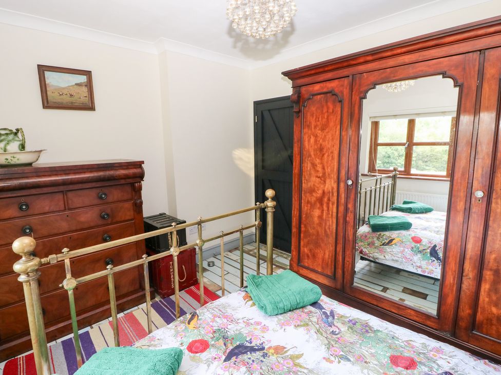 A bedroom with a bed, wardrobe, and chest of drawers at The Woodlands Lower Level in Stepaside