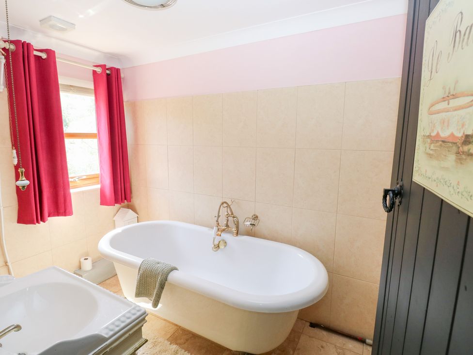 A bathroom with a bathtub and sink at The Woodlands Lower Level in Stepaside