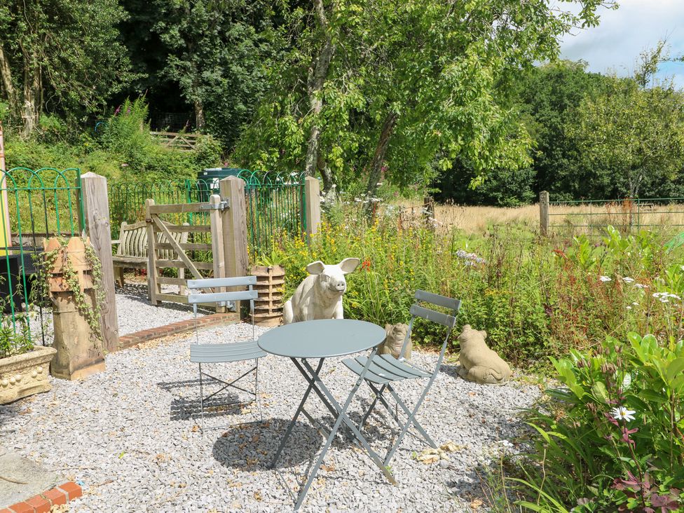 A garden with a table, chairs, and animal statues at The Woodlands Lower Level in Stepaside