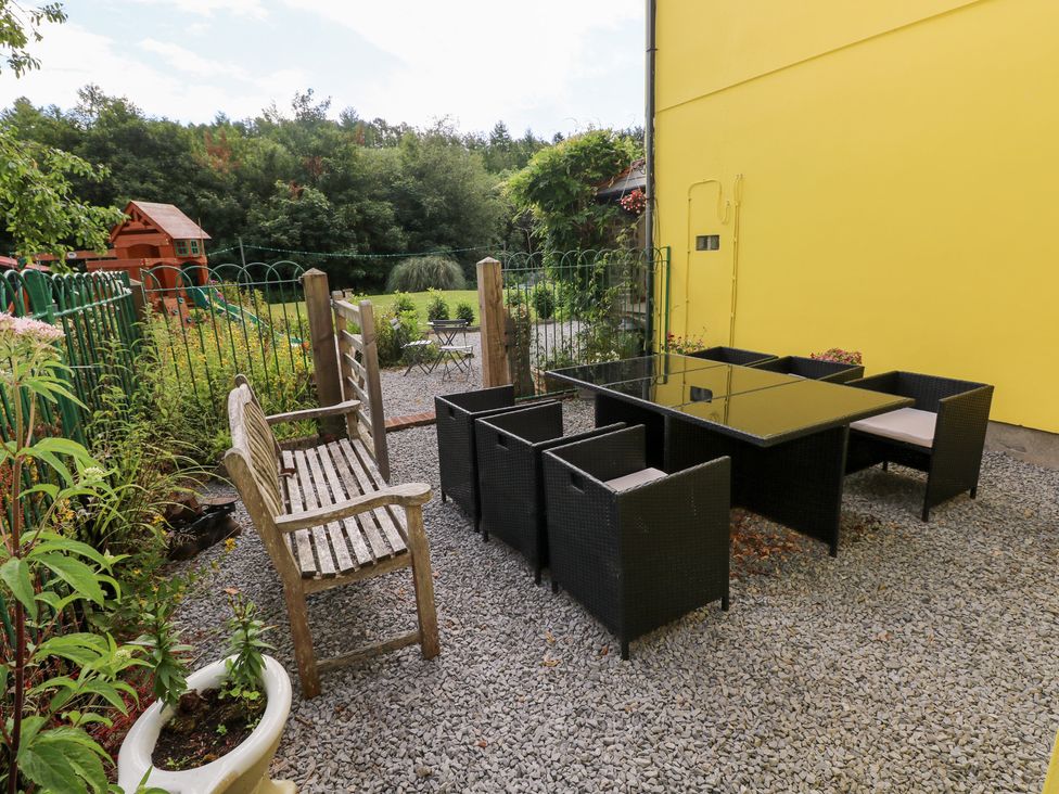 An outdoor seating area with a bench and dining table at The Woodlands Lower Level in Stepaside