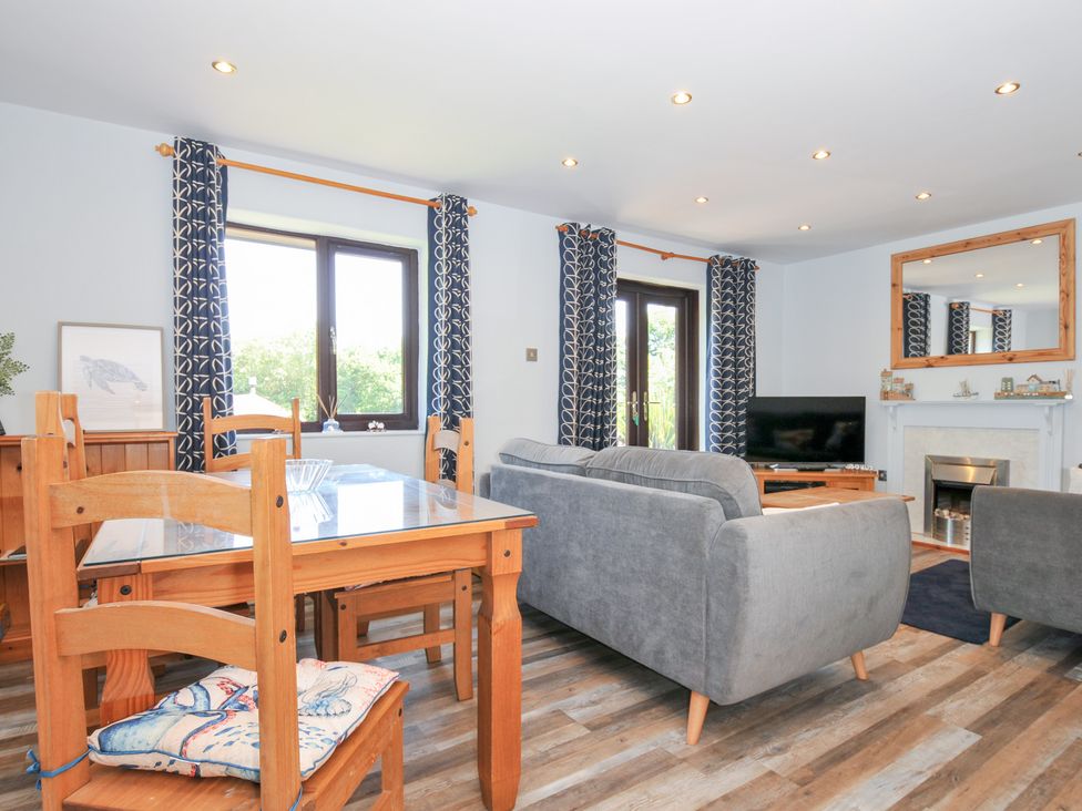 A living room with a dining table and sofa at Columbine Cottage in Bude
