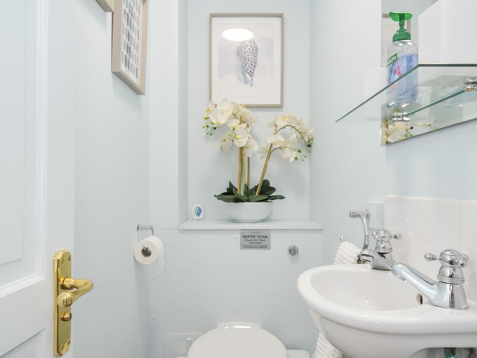 A bathroom with a toilet and sink at Columbine Cottage in Bude