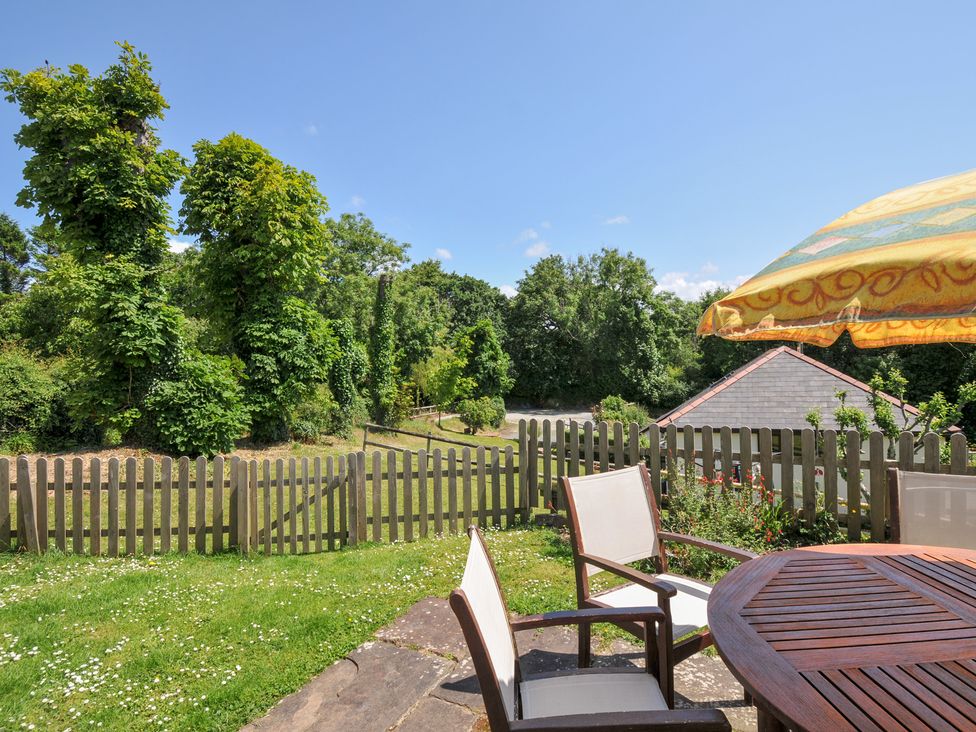 A garden with a table and chairs at Columbine Cottage in Bude