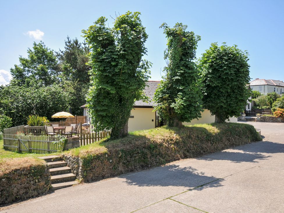 A house with trees and garden furniture at Columbine Cottage in Bude