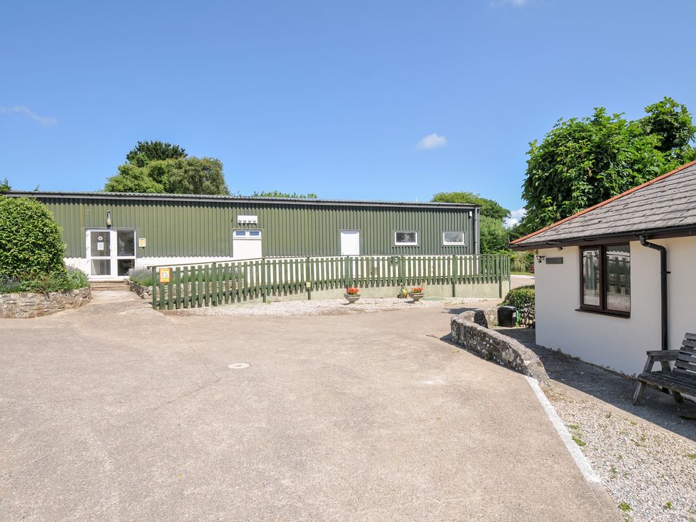 An outdoor view of a green building and a white building at Columbine Cottage in Bude