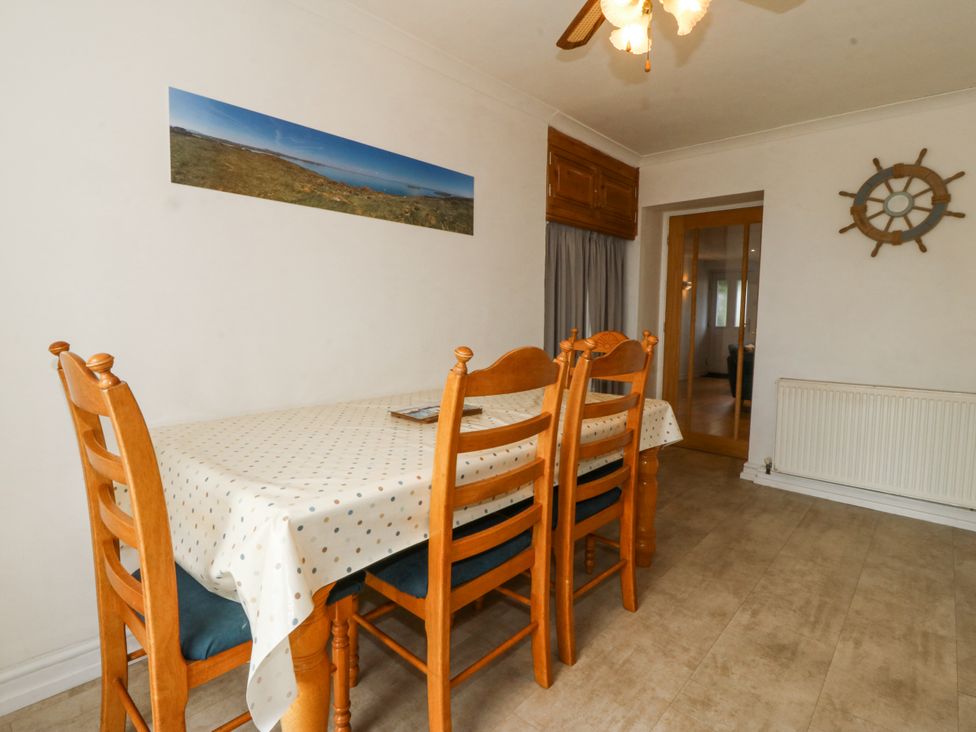 A dining room with a table and chairs at Bryn Awel in Mynytho near Abersoch