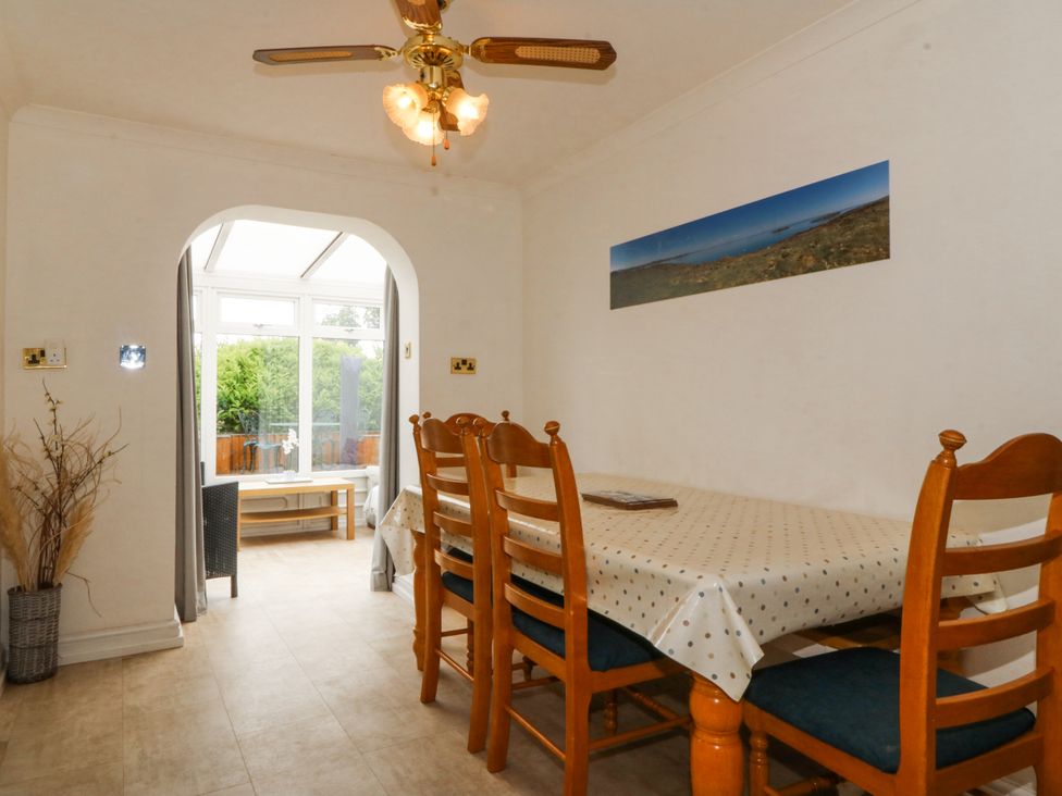A dining room with a table and chairs at Bryn Awel in Mynytho near Abersoch