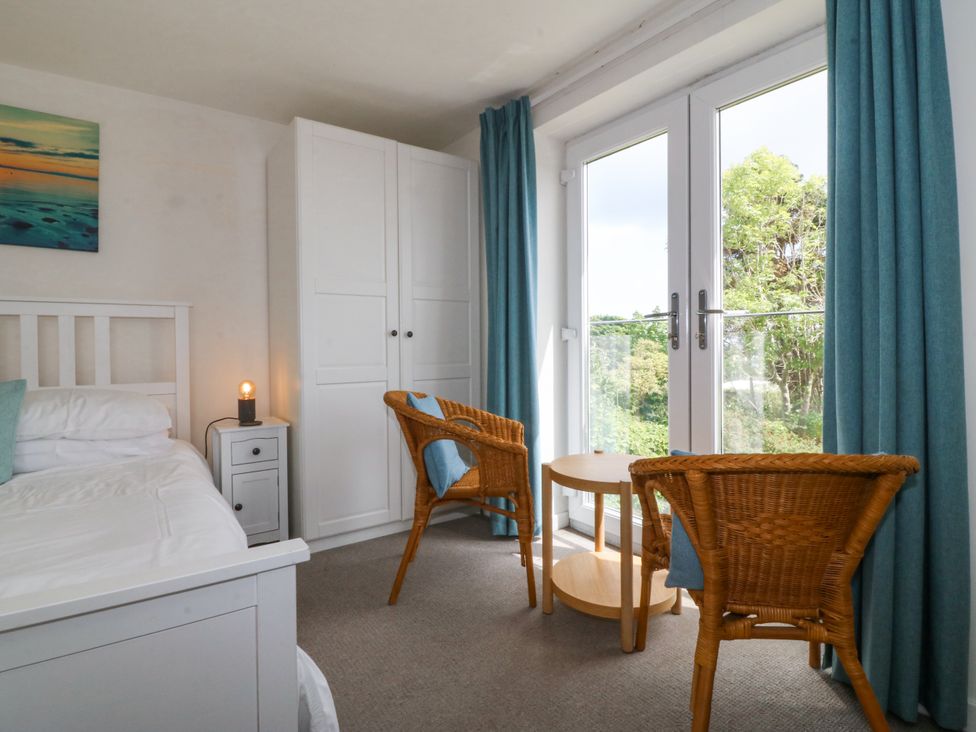 A bedroom with a bed and chairs at Bryn Awel in Mynytho near Abersoch