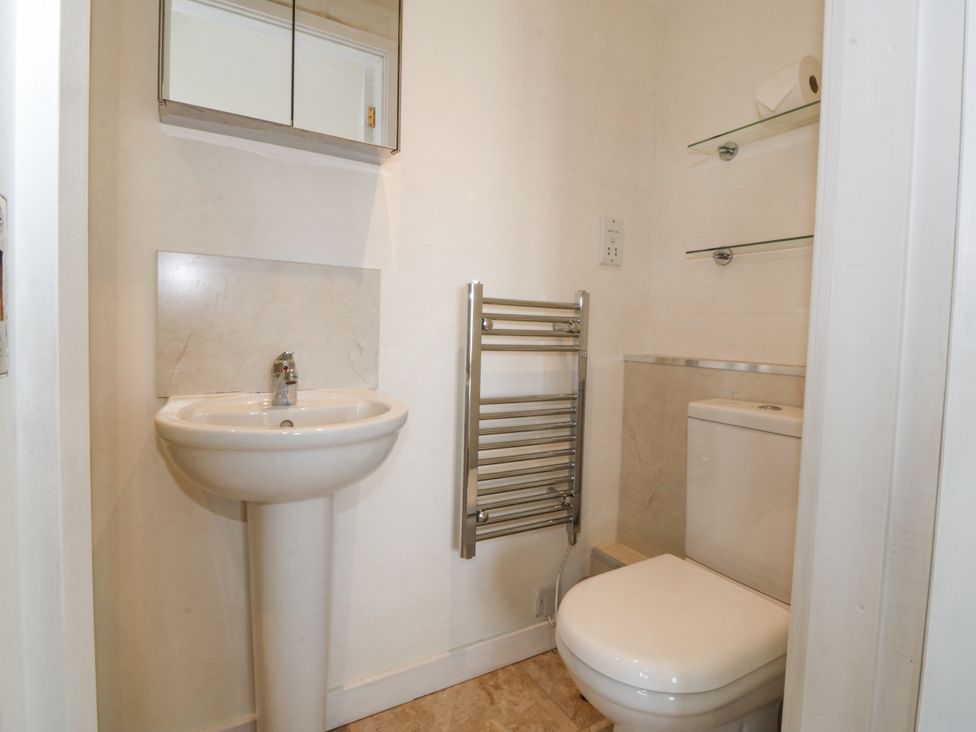 A bathroom with a sink, toilet, and towel rail at Bryn Awel in Mynytho near Abersoch