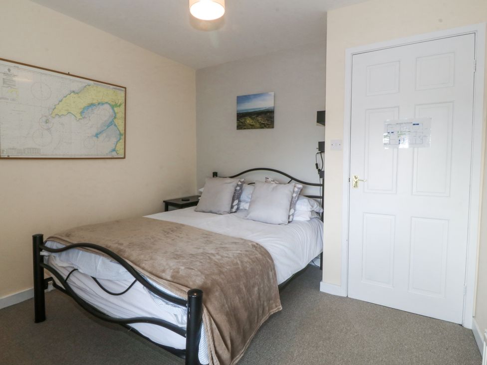 A bedroom with a bed and wall decor at Bryn Awel in Mynytho near Abersoch