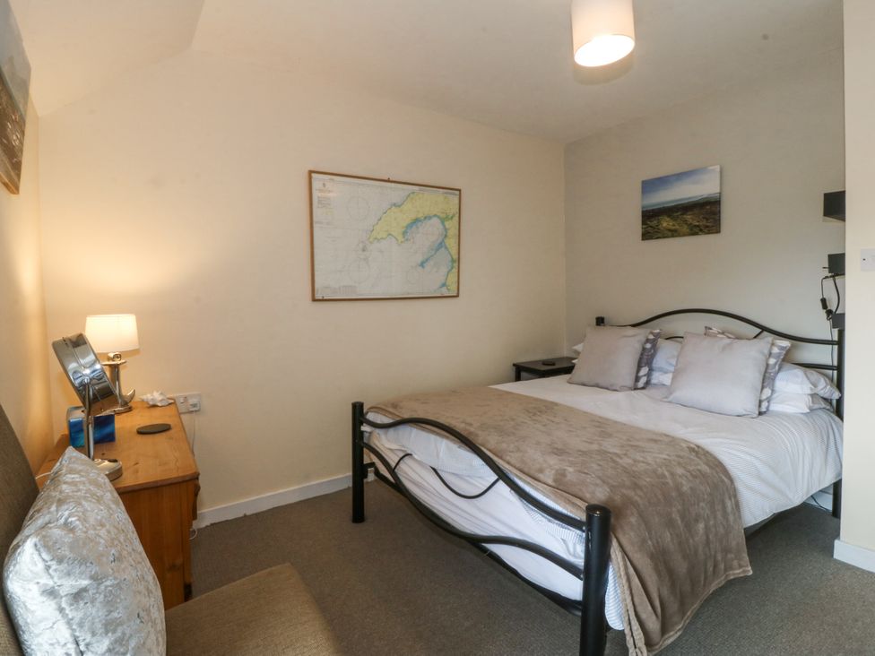 A bedroom with a bed and table at Bryn Awel Mynytho near Abersoch