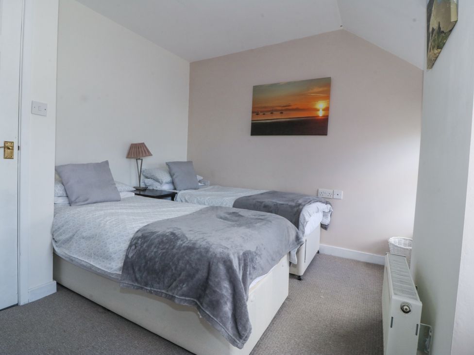 A bedroom with two beds and a painting at Bryn Awel Mynytho near Abersoch