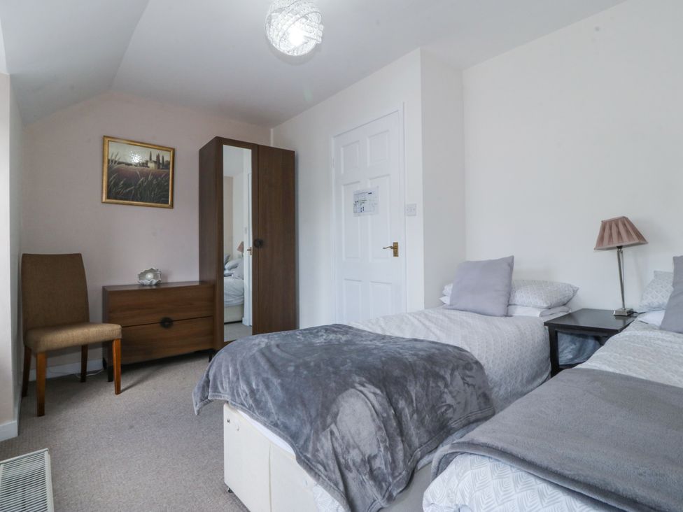 A bedroom with twin beds and a wardrobe at Bryn Awel in Mynytho near Abersoch