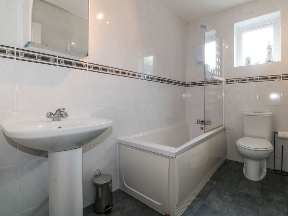 A bathroom with a sink, toilet, and bathtub at Bryn Awel in Mynytho near Abersoch