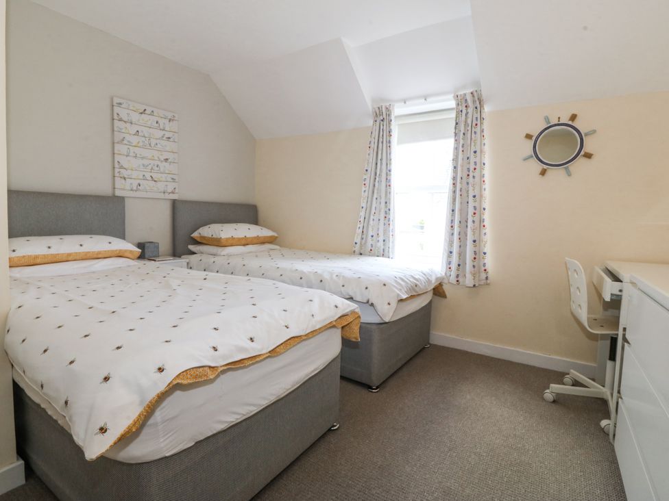 A bedroom with two beds and a desk at Bryn Awel in Mynytho near Abersoch