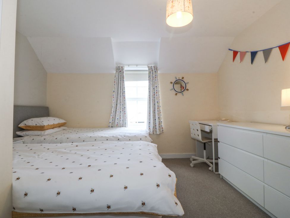 A bedroom with two beds and a desk at Bryn Awel in Mynytho near Abersoch