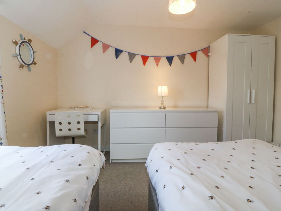 A bedroom with two beds, a desk, and a wardrobe at Bryn Awel in Mynytho near Abersoch