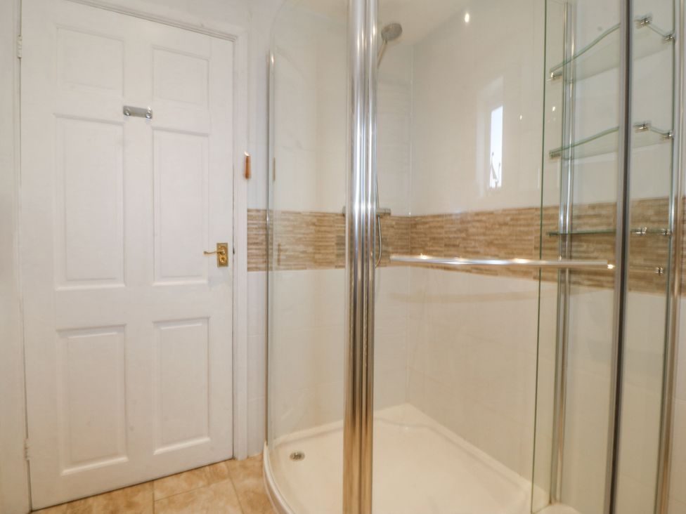 A bathroom with a shower and door at Bryn Awel in Mynytho near Abersoch