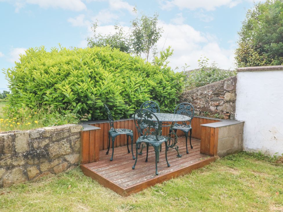 An outdoor seating area with a table and chairs at Bryn Awel in Mynytho near Abersoch