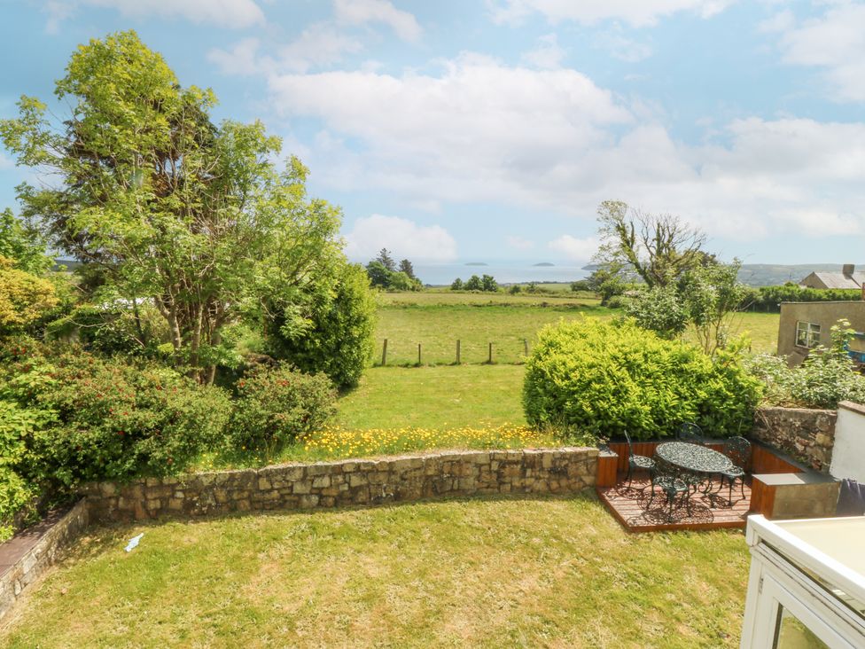 A garden with a table and chairs at Bryn Awel in Mynytho near Abersoch