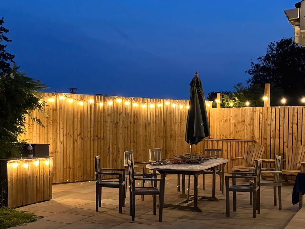 An outdoor patio with table and chairs at Gilfach in Abersoch