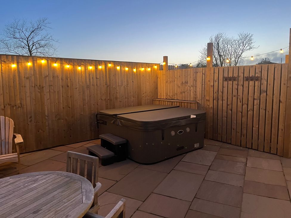 A hot tub with steps and seating area at Gilfach in Abersoch