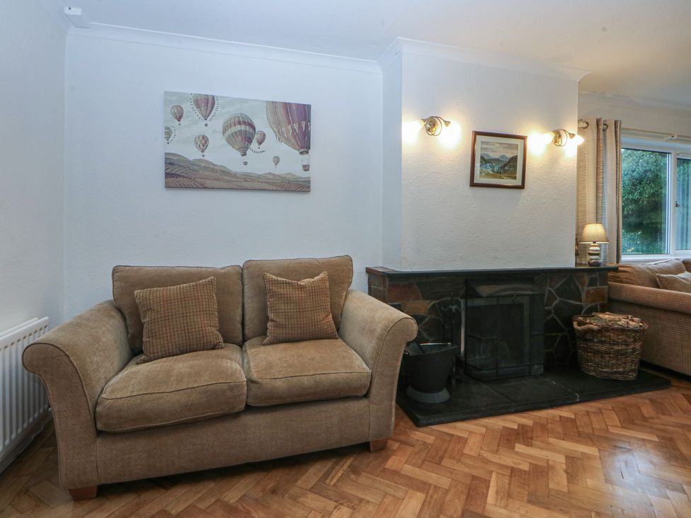 A living room with a sofa and fireplace at Lane End in Abersoch