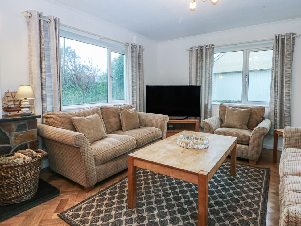 A living room with a sofa and armchairs at Lane End in Abersoch