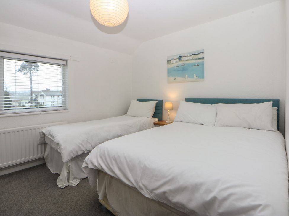 A bedroom with two beds and a window at Lane End in Abersoch