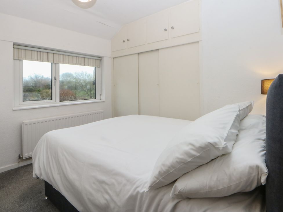 A bedroom with a bed and window at Lane End in Abersoch