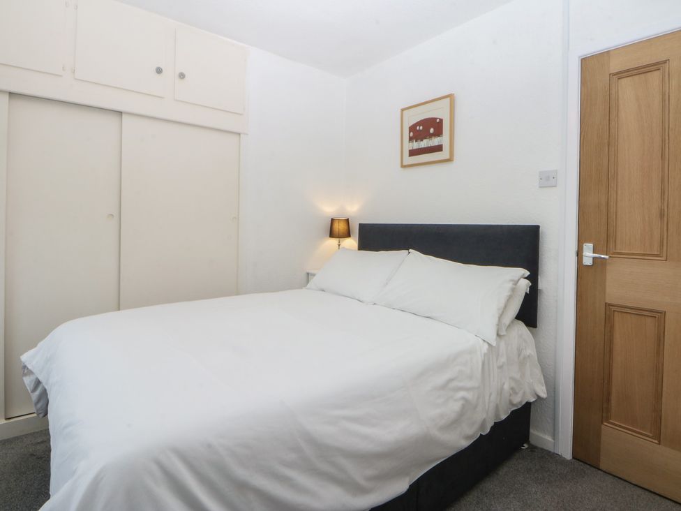 A bedroom with a bed and a wardrobe at Lane End in Abersoch