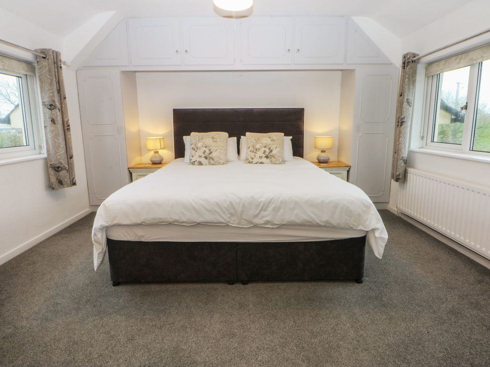 A bedroom with a bed and bedside tables at Lane End in Abersoch