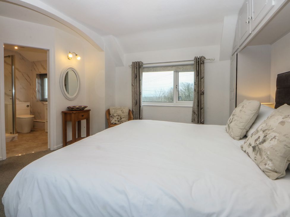 A bedroom with a bed and a window at Lane End in Abersoch