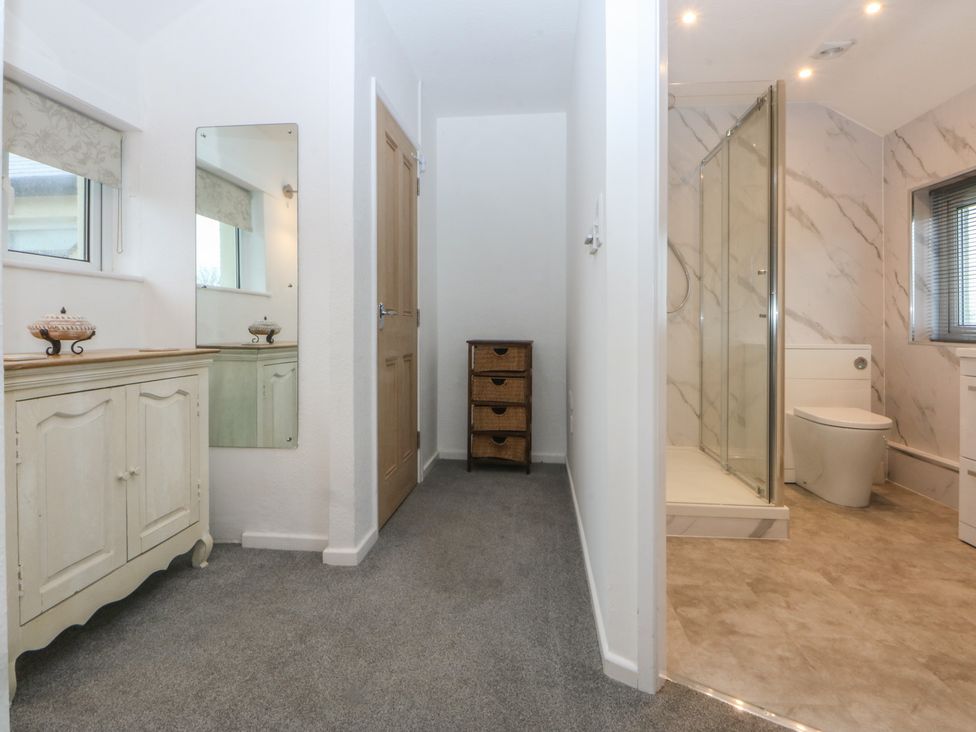 A bathroom with a shower and washstand at Lane End in Abersoch