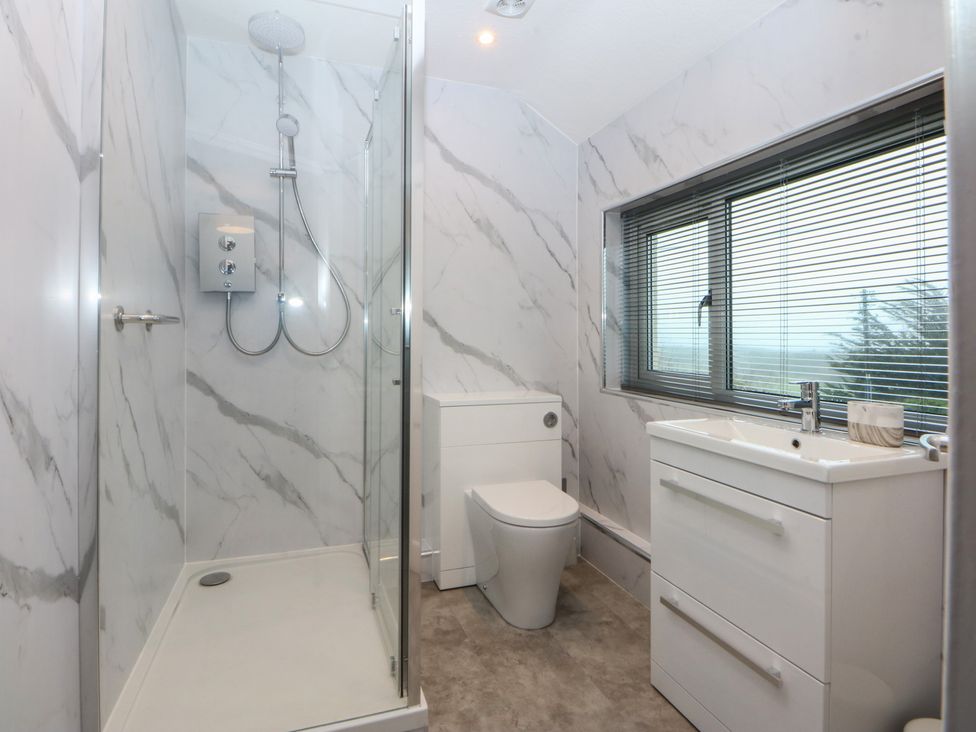 A bathroom with a shower, toilet and sink at Lane End in Abersoch