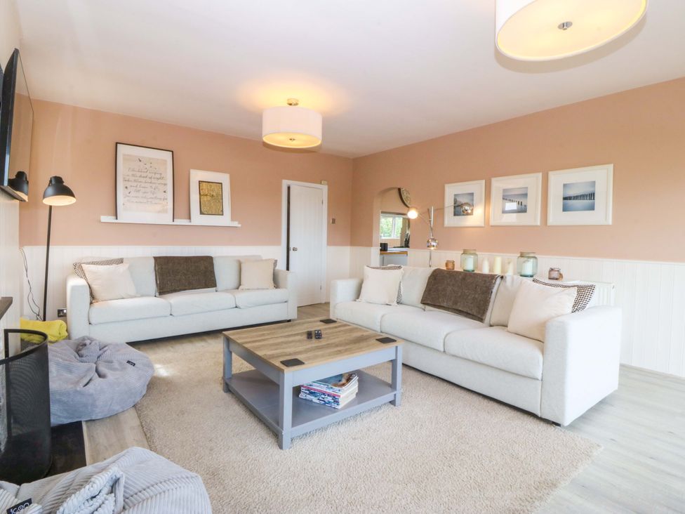 A living room with a sofa and coffee table at Nyth Y Fran in Abersoch