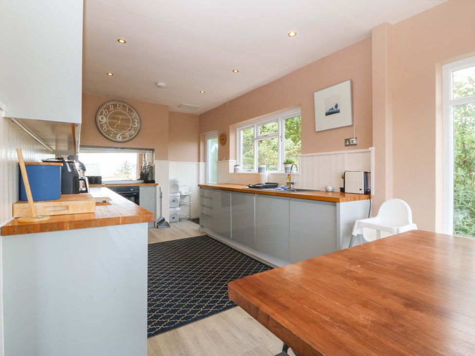 A kitchen with countertops and a clock at Nyth Y Fran in Abersoch