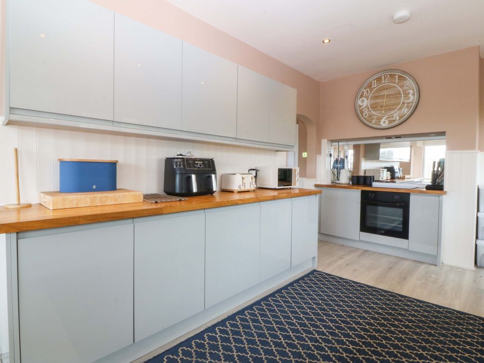 A kitchen with cabinets and appliances at Nyth Y Fran in Abersoch