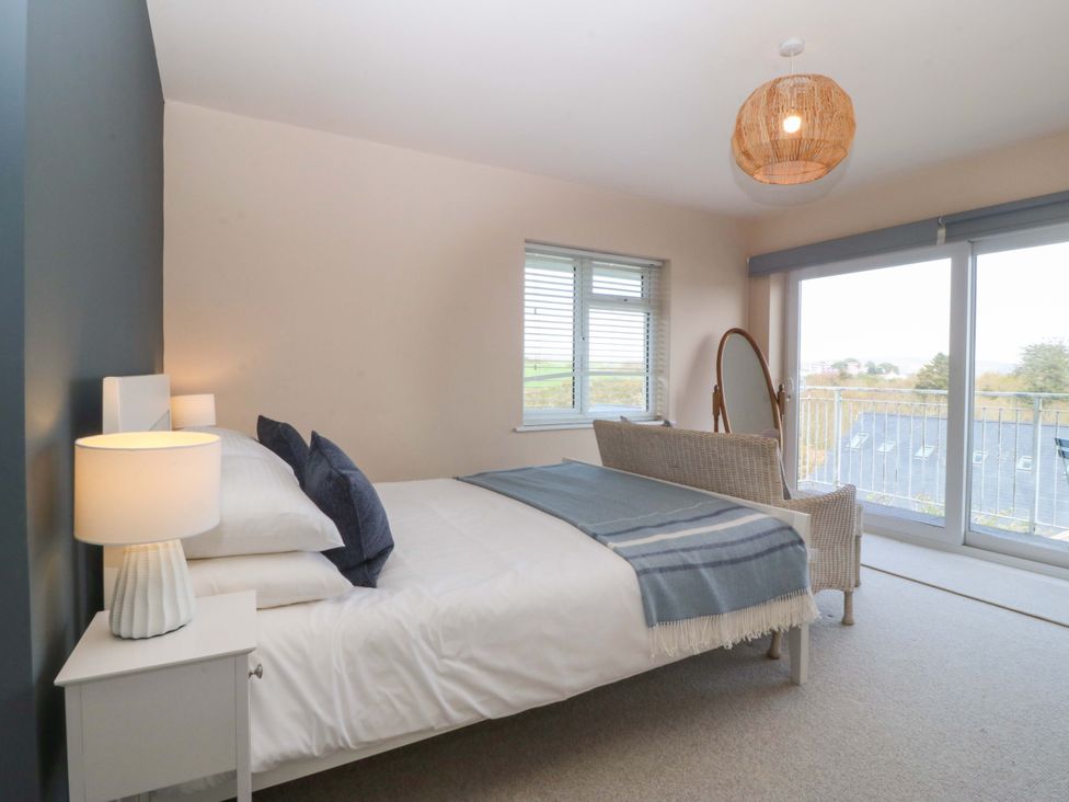 A bedroom with a bed and large window at Nyth Y Fran in Abersoch